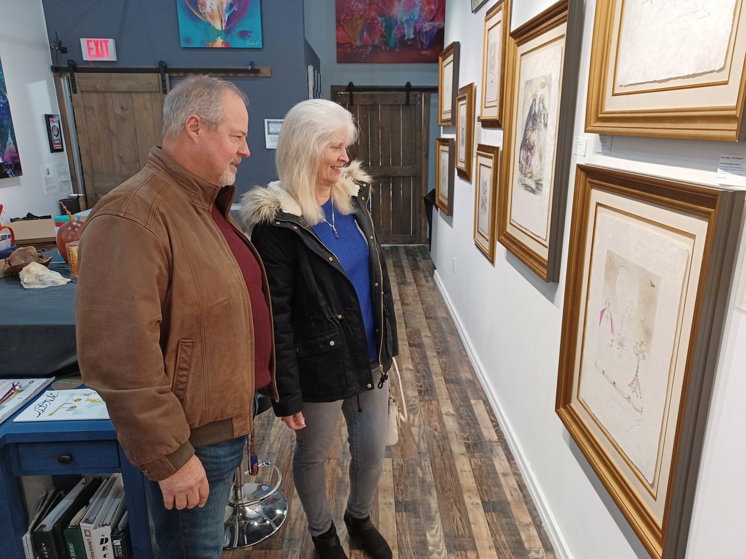 Chris and Marci Connelly examine etchings by Salvador Dali, currently on display at Gallery 725 in Jacksonville Beach.